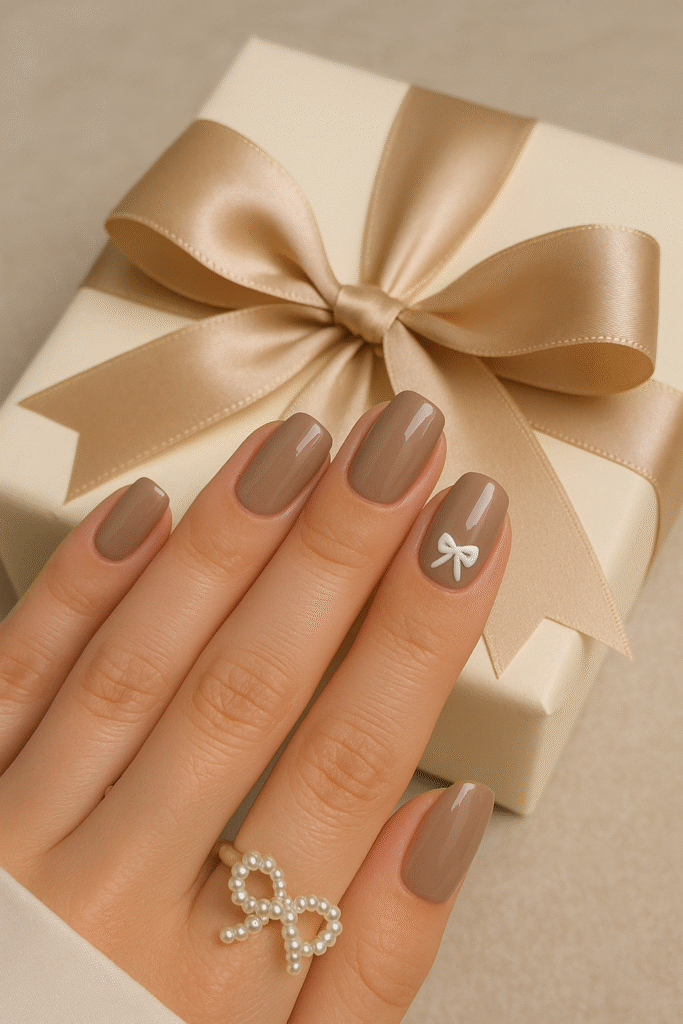 Glossy Taupe Nails with a White Bow Accent